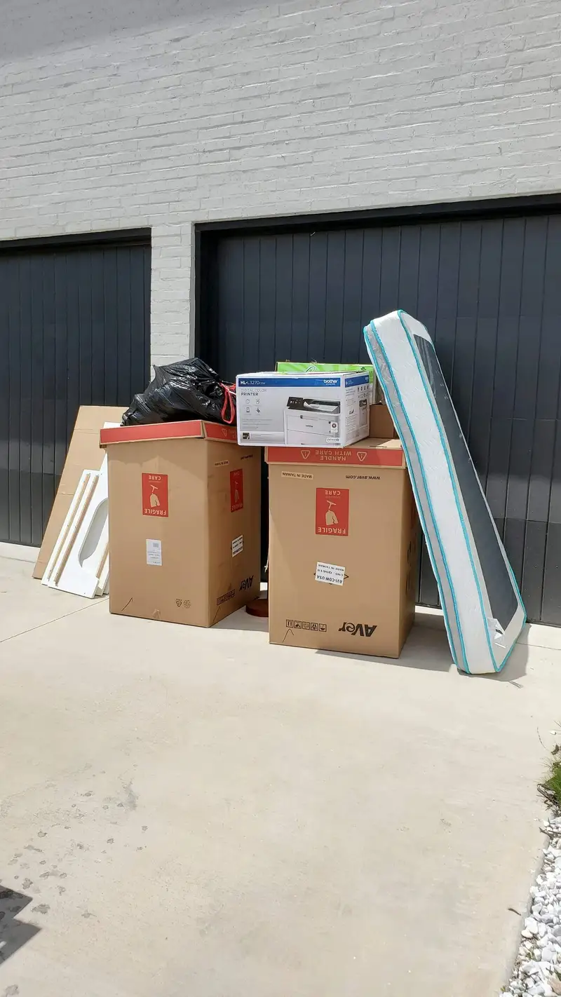 Mattress, boxes and unwanted household items ready for a driveway pickup